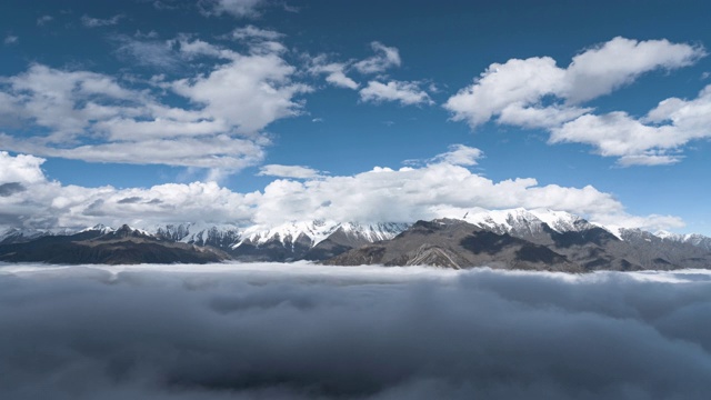 宽镜头时间流逝白色蓬松的云在蓝天之上雪山视频素材