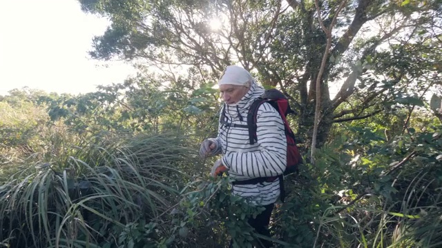 两个白人男人在草地上走着要上山。视频素材