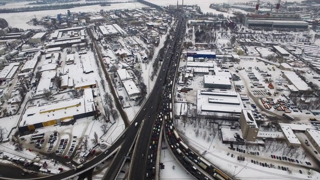 鸟瞰图汽车运动的公路交叉口城市。冬天的城市道路视频素材