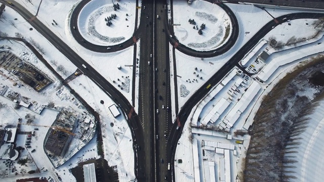 俯视图汽车交通高速公路立交桥。汽车在积雪的公路十字路口行驶视频素材