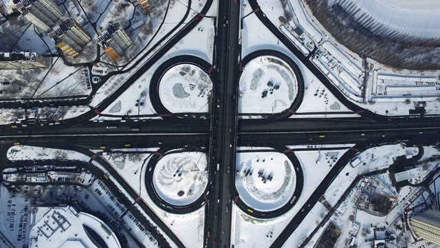 无人机在城市的高速公路立交桥。积雪覆盖的公路交叉处的汽车交通视频素材