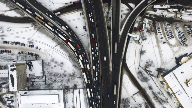 顶视图汽车驾驶冬季高速公路。鸟瞰图交通积雪公路路口视频素材