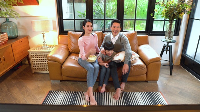 一个家庭在家里的沙发上看电视的高角度正面视图视频素材画面1