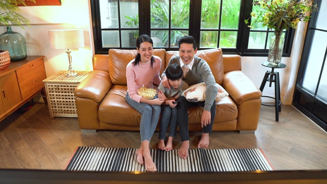 一个家庭在家里的沙发上看电视的高角度正面视图视频素材画面2
