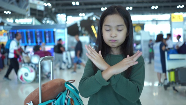 旅程的亚洲小女孩在机场，等待她的航班，面部表情，停止，不，拒绝，否认视频素材