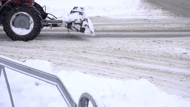 扫雪机在城市的道路上，雪很多，冬天，城市，慢动作，拖拉机视频素材