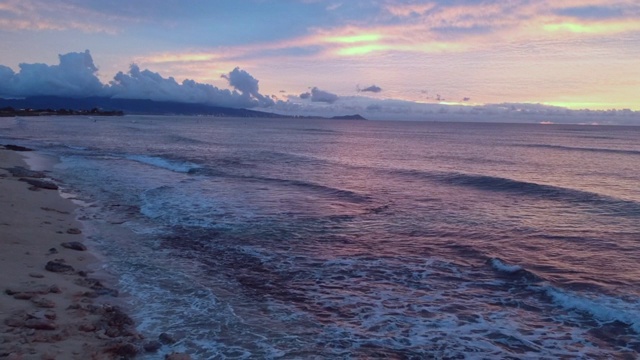 日出时，在海滩和海岸上空进行空中向前飞行视频素材