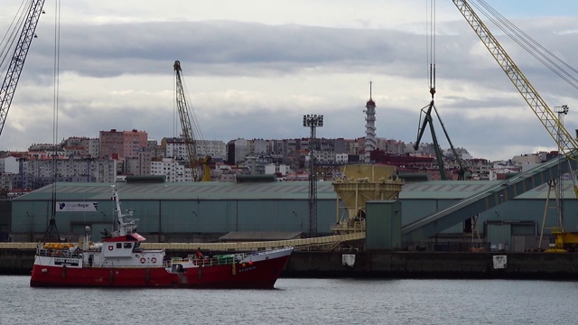 这艘船以港口为背景。港口城市La Coruña，西班牙。视频素材