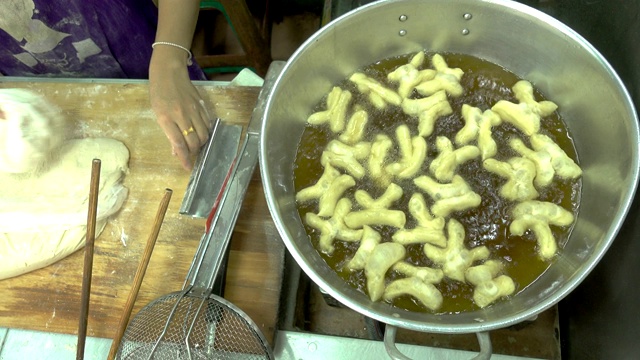 俯视图油条烹饪和手工制作，是亚洲各国著名的街头小吃。视频素材