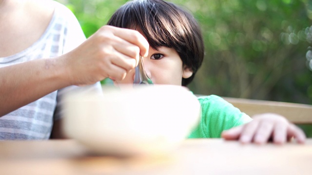 可爱的男孩和妈妈一起吃早餐视频素材