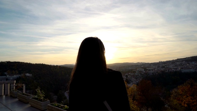 美丽的女孩凝视日落云彩在风景优美的山在Veliko Tarnovo，保加利亚视频素材画面1
