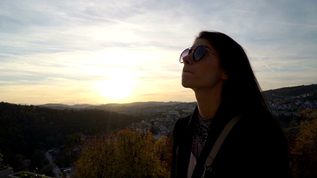 美丽的女孩凝视日落云彩在风景优美的山在Veliko Tarnovo，保加利亚视频素材画面3
