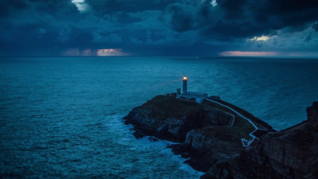 灯塔带着光在暴风雨的海岸线视频素材