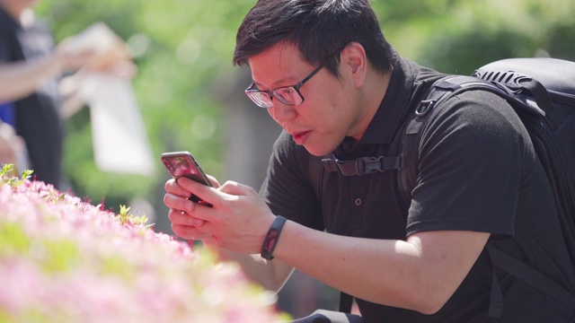 日本，一名男子在公园用手机拍照。视频素材