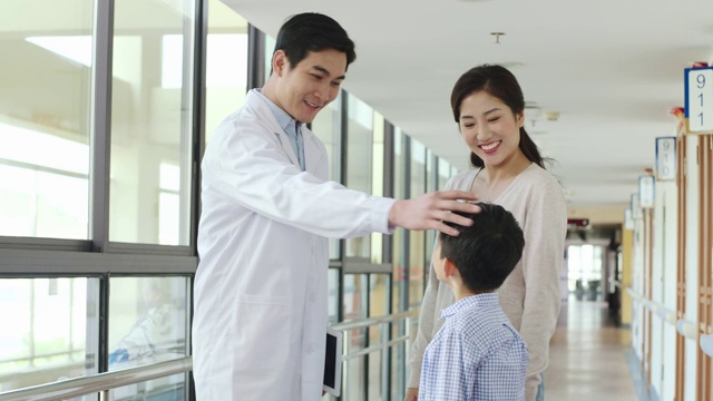 亚洲医生与母亲和儿子在医院交谈视频素材画面1