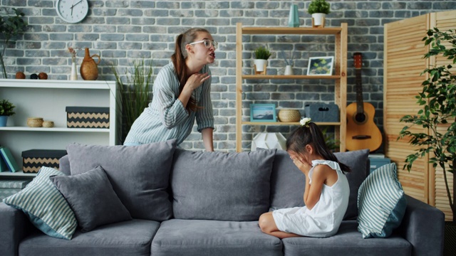 愤怒的母亲惩罚顽皮的女儿，在孩子哭闹时摇手指视频素材