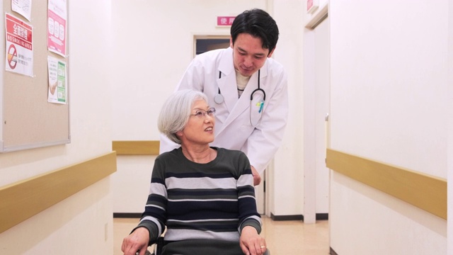 日本医生与轮椅上的病人交谈视频素材画面1