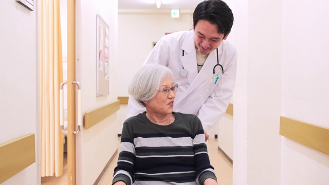 日本医生与轮椅上的病人交谈视频素材画面2