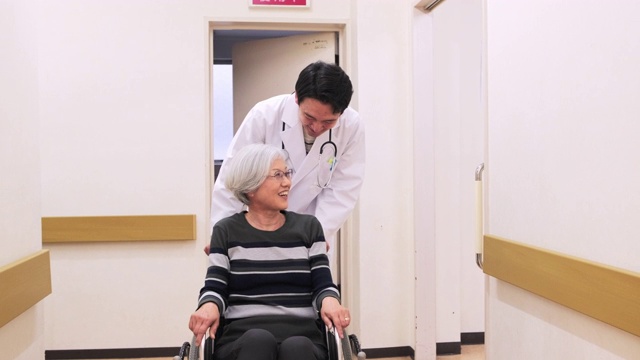 日本医生与轮椅上的病人交谈视频素材画面4