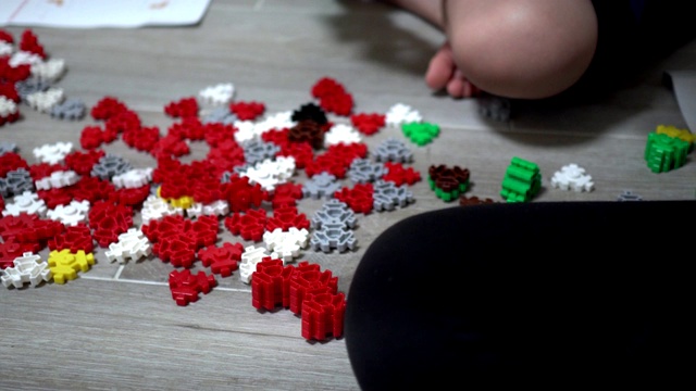 小孩子在室内玩许多五颜六色的塑料玩具。主题在右边。视频素材画面1