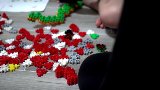 小孩子在室内玩许多五颜六色的塑料玩具。主题在右边。视频素材画面2