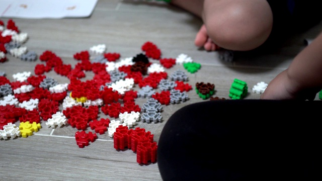 小孩子在室内玩许多五颜六色的塑料玩具。主题在右边。视频素材画面3