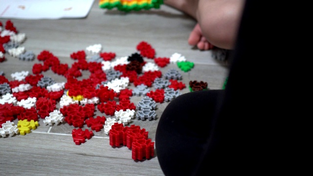 小孩子在室内玩许多五颜六色的塑料玩具。主题在右边。视频素材画面4