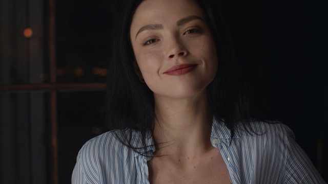 一个漂亮的女孩看着镜头微笑着。4 k超高清的视频素材画面2