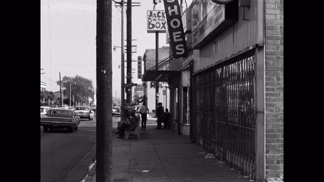 1960年的今天，美国加利福尼亚州洛杉矶市一家商店前的宽阔街道上行驶的车辆视频素材