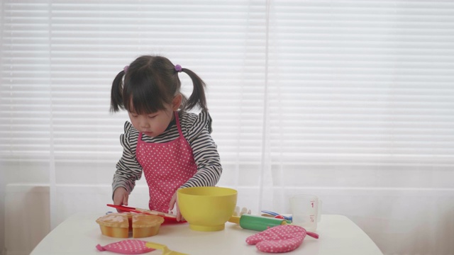 蹒跚学步的小女孩假装玩准备食物的游戏视频素材