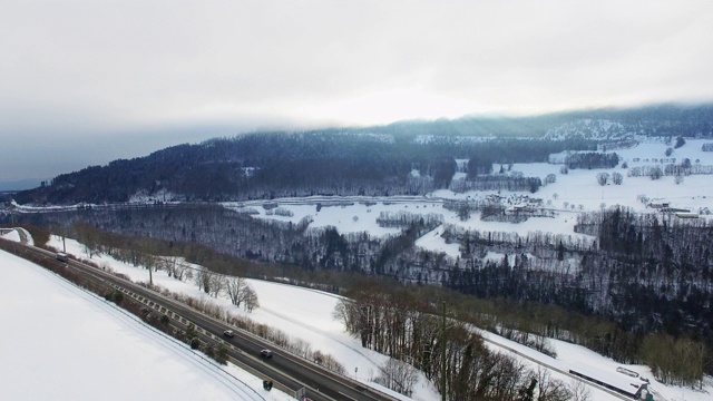 飞过一条公路，后面是白雪覆盖的森林视频下载