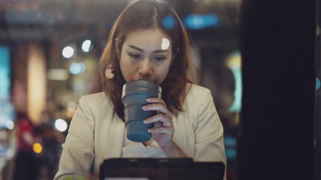 亚洲女商人晚上在咖啡馆用笔记本电脑。视频素材