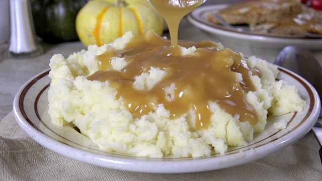 将肉汁浇在土豆泥上的慢动作视频素材