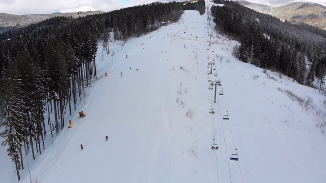 鸟瞰冬季滑雪场的滑雪坡道及滑雪缆车视频素材