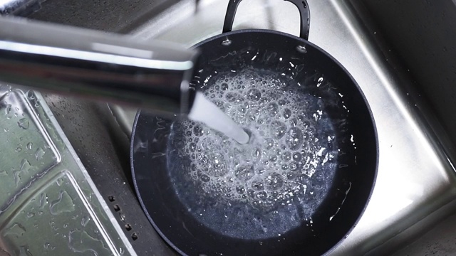 水从水龙头流入水槽，被倒入锅中特写，相机运动视频素材