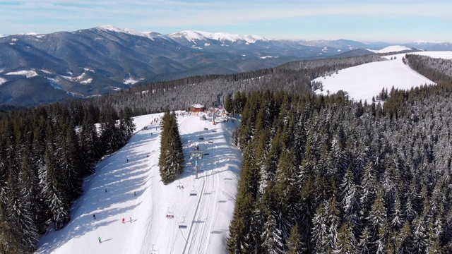 滑雪胜地的空中滑雪场与滑雪者和滑雪缆车。的雪山森林视频素材