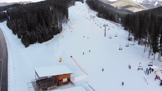 鸟瞰冬季滑雪场的滑雪坡道及滑雪缆车视频素材