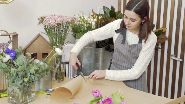 年轻女子花匠正在花店或花房里制作一束郁金香视频素材