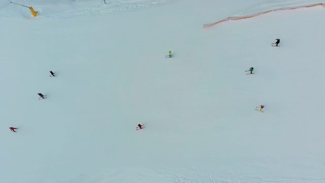 顶部鸟瞰图滑雪者滑下滑雪场的雪坡在冬季视频素材