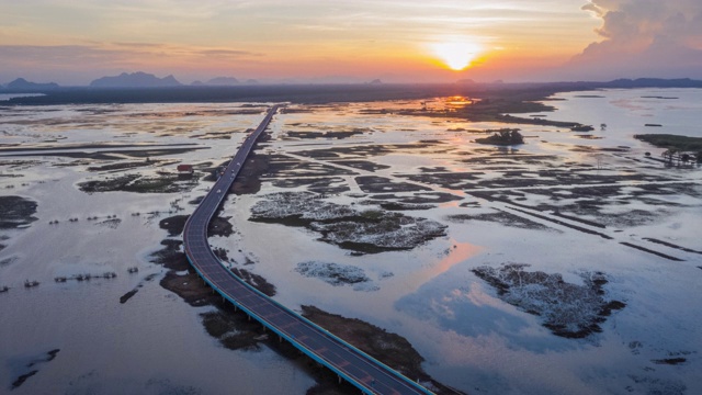 高速公路在夕阳下越过水边平原视频素材