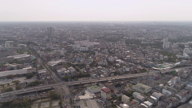 空中拍摄的车辆在街道上的建筑物对天空，无人机飞过城市景观在阳光明媚的一天-曼谷，泰国视频素材