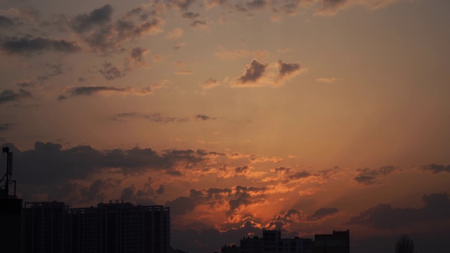 城市剪影与一个戏剧性的日落橙色云和太阳圆盘视频素材