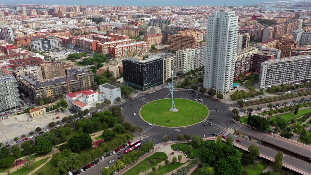 西班牙巴伦西亚，空中倾斜拍摄在城市建筑中回旋处的车辆，无人机飞向建筑物视频素材