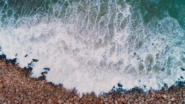 海浪撞击海岸线上的岩石的鸟瞰图视频素材