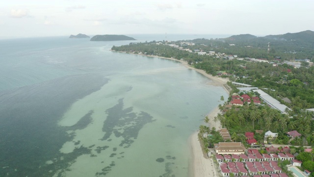 航拍城市从海上对天空，无人机向前飞在海岸线上的棕榈树上-科帕颜，泰国视频素材