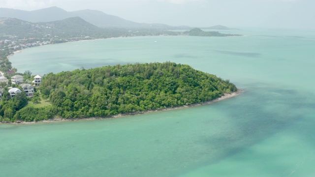 在阳光明媚的日子里，空中拍摄房屋和绿松石海旁的植物，无人机在海洋上空飞行-苏梅岛，泰国视频素材