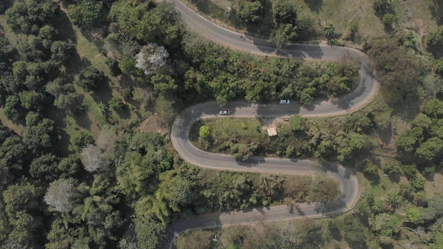 以森林山为背景的沥青蜿蜒道路鸟瞰图。通过无人机安全驾驶和旅行理念，欣赏陡峭弯道的风景。视频素材