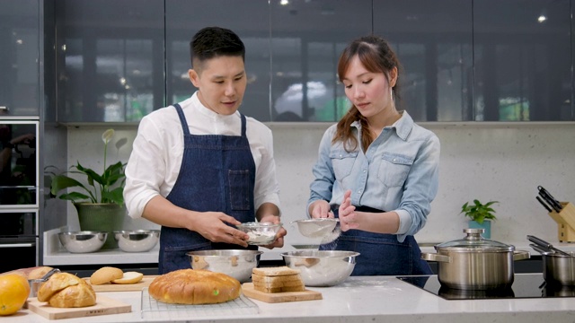 年轻的亚洲夫妇在厨房里摆桌子准备早餐时，又跳又唱。视频素材