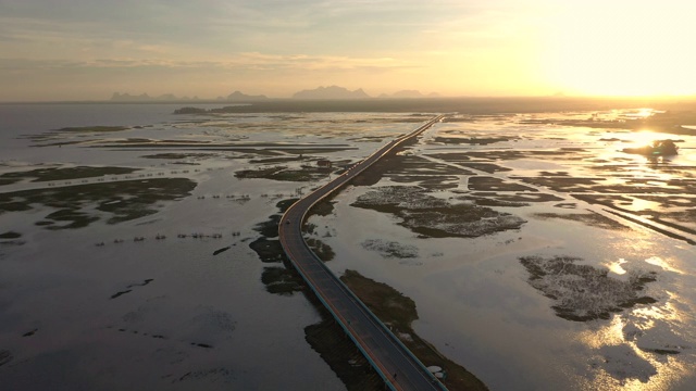 高速公路在夕阳下通过水边平原视频素材