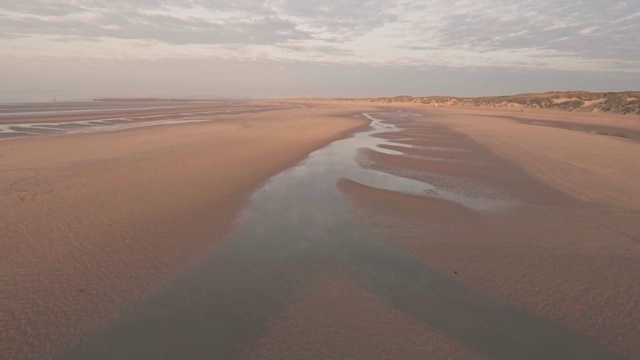 夕阳西下的英国东苏塞克斯坎伯沙滩。空中无人机视图视频素材